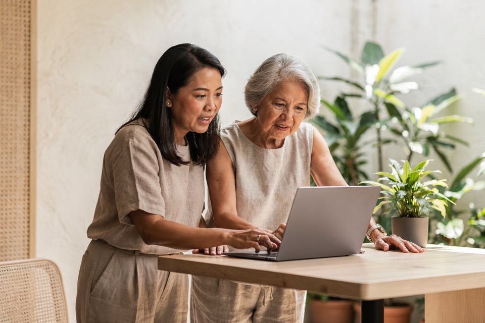 Hotel manager and operations colleague reviewing performance together on one laptop